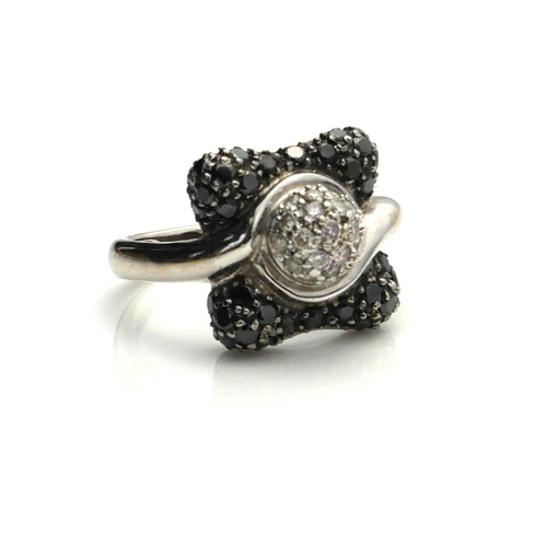 390 - A 14CT WHITE GOLD, BLACK AND WHITE DIAMOND RING
The cluster of diamonds in a half twist edged with b... 