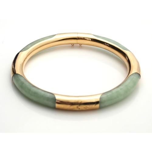 391 - A 14CT GOLD AND CHINESE JADE BANGLE /BRACELET
Circular carved green jade with 14ct gold overlay. 
(a... 