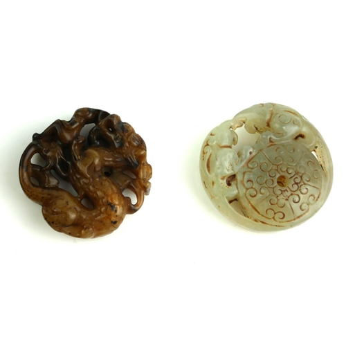 510 - TWO CHINESE CARVED JADE ROUNDELS
A brown jade dragon with pierced detail and a green jade roundel wi... 