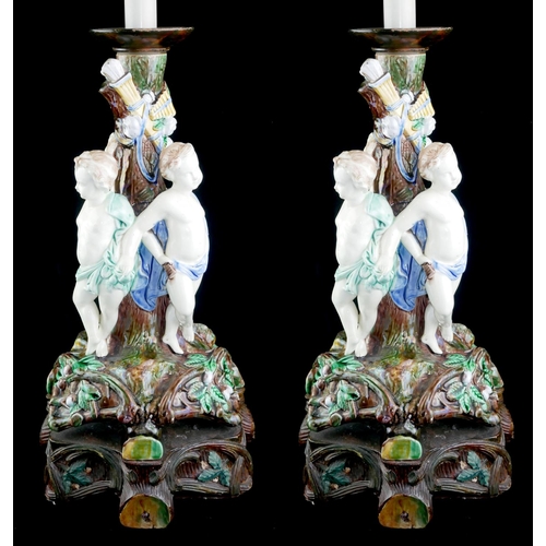 514 - A PAIR OF 20TH CENTURY MINTON MAJOLICA STYLE FIGURAL LAMP BASES MODELLED AS THREE PUTTI IN RELIEF 
P... 