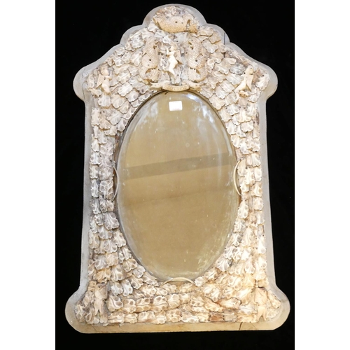 520 - A 19TH CENTURY FRENCH IVORY FRAMED MIRROR
Figured with a cherub flanked by dragons above an oval bev... 