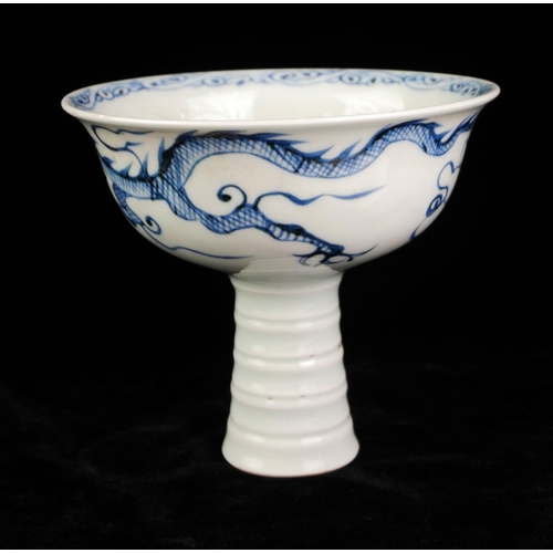 524 - A 20TH CENTURY CHINESE DESIGN BLUE AND WHITE PORCELAIN STEM CUP
Interior moulded with a dragon chasi... 