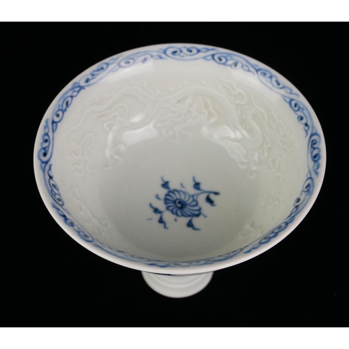 524 - A 20TH CENTURY CHINESE DESIGN BLUE AND WHITE PORCELAIN STEM CUP
Interior moulded with a dragon chasi... 