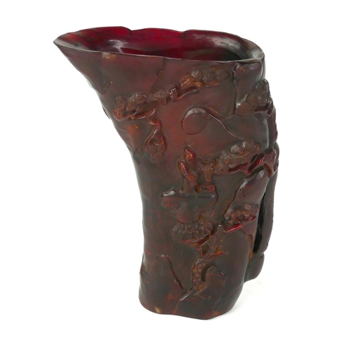 535 - A CHINESE CARVED HORN LIBATION CUP
Red stained with carved decoration of figures in a mountainous la... 