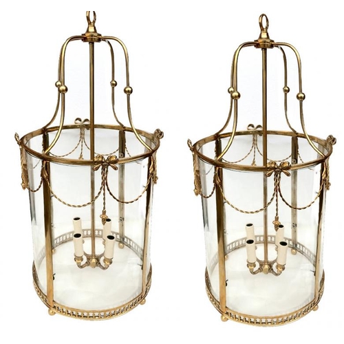 567 - A PAIR OF BRASS LANTERNS IN THE REGENCY STYLE
With four glass sections and rope twist swags above a ... 