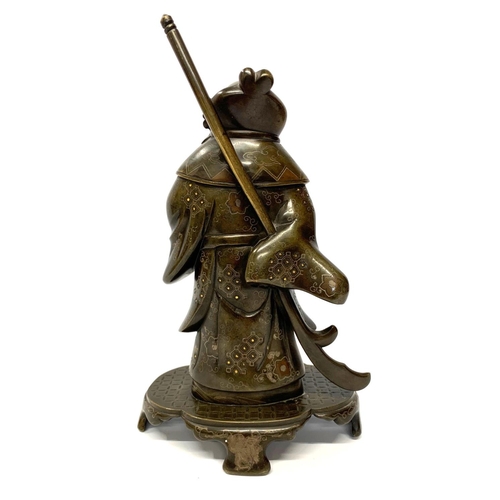 577 - A JAPANESE MEIJI PERIOD BRONZE MODEL OF A WARRIOR 
With gilt and silver decoration, on a shaped base... 