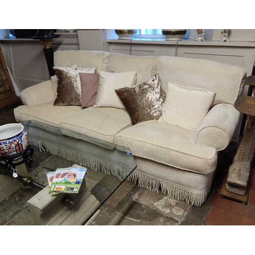 705 - A PAIR OF GOOD QUALITY THREE SEATER SOFAS
Upholstered in a cut cream fabric, complete with loose cus... 