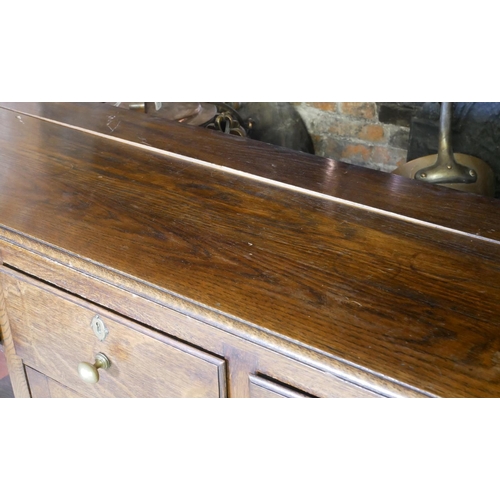 712 - A 19TH CENTURY OAK DRESSER
With three drawers above a central cupboard, on square legs.
(152cm x 50c... 