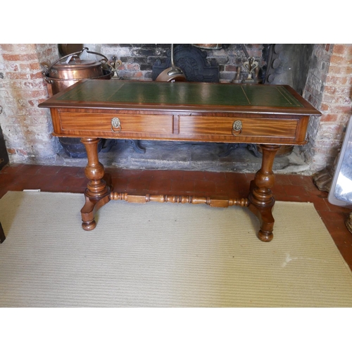 713 - A VICTORIAN MAHOGANY WRITING TABLE
With green tooled leather top above two drawers, raised on two co... 