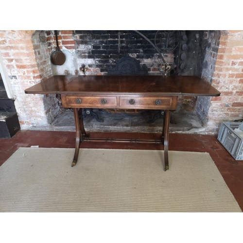 736 - A REGENCY STYLE MAHOGANY SOFA TABLE
With real and false drawers, raised on splayed legs joined by ri... 