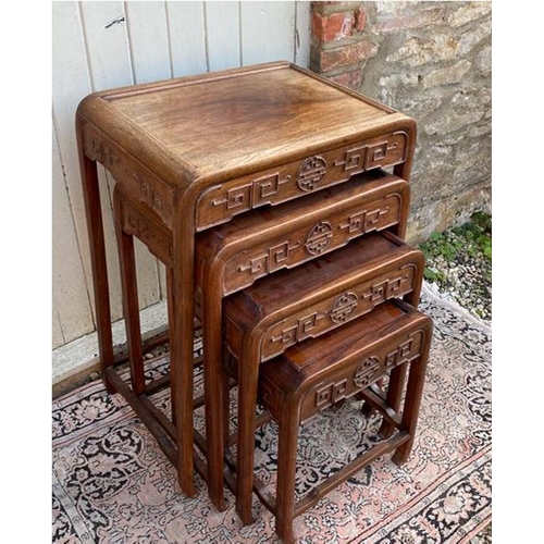 779 - A SET OF FOUR EARLY 20TH CENTURY CHINESE HARDWOOD NESTING TABLES
The square section tops over round ... 