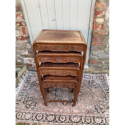 779 - A SET OF FOUR EARLY 20TH CENTURY CHINESE HARDWOOD NESTING TABLES
The square section tops over round ... 