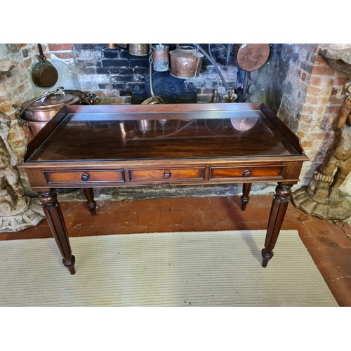 752 - A VICTORIAN MAHOGANY WRITING TABLE
With galleried back above three drawers, raised on turned fluted ... 