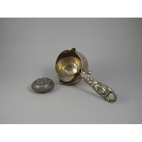 436 - A SILVER TRIPOD TEA STRAINER 
With fine dragon handle in low relief, marked ‘Tuck Chang’, along with... 