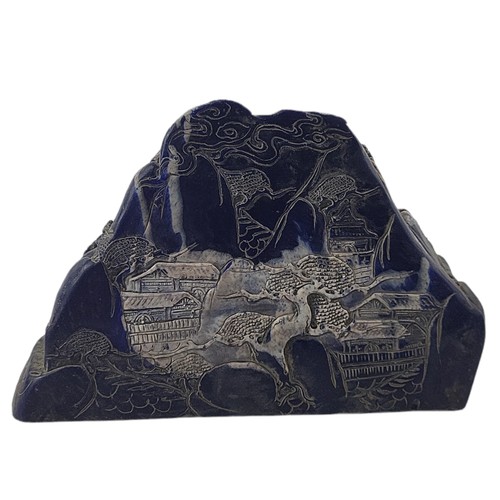 25 - A CARVED LAPIS LAZULI COBBLE 
Depicting a Chinese gathering in relief.
(h 14cm x length 20cm)

Condi... 