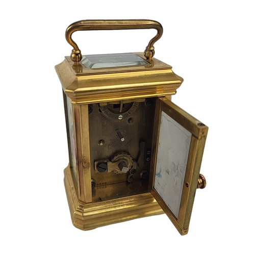 84 - A MINIATURE SÈVRES STYLE FRENCH PORCELAIN AND POLISHED BRASS CARRIAGE CLOCK 
Having a glass top and ... 