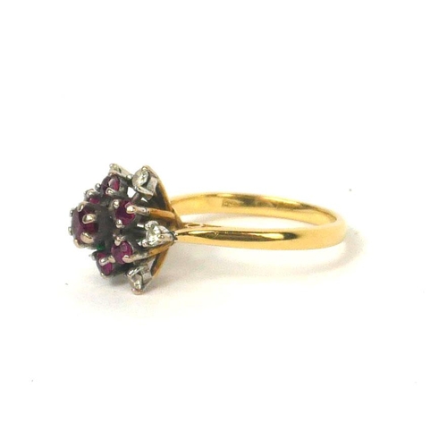 77 - A VINTAGE 18CT GOLD, RUBY AND DIAMOND CLUSTER RING
Having an arrangement of round cut rubies edged w... 
