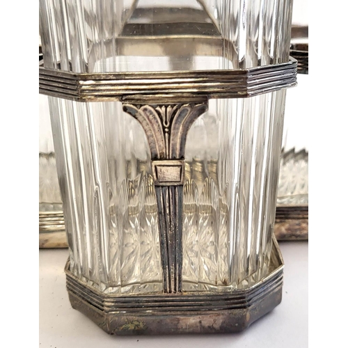 39 - A GEORGIAN SILVER AND CUT GLASS FOUR BOTTLE DECANTER SET
Having a reeded handle, on classical urn fo... 