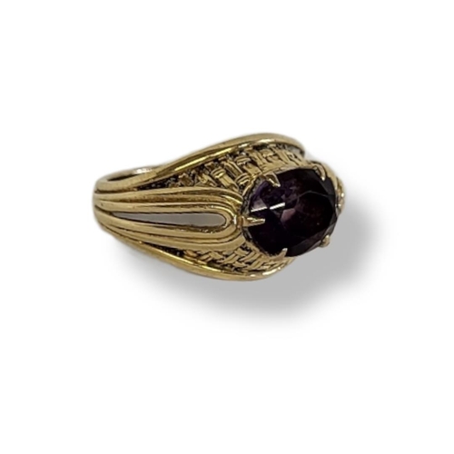 2a - A VINTAGE YELLOW METAL AND AMETHYST GENTS SIGNET RING
Having a single oval cut stone and engraved de... 