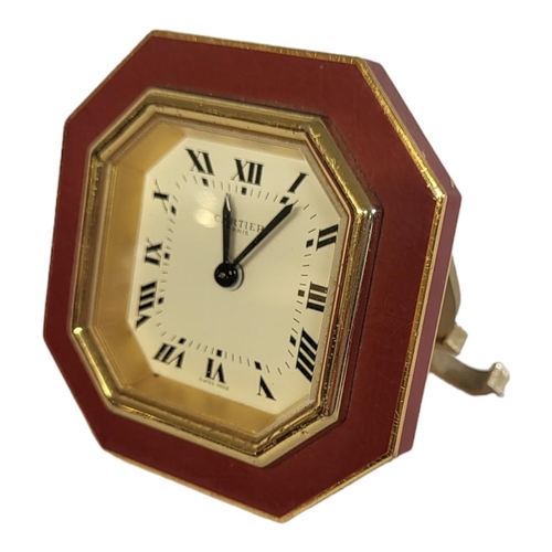 46 - CARTIER, MUST DE CARTIER, A VINTAGE GILT METAL AND ENAMEL TRAVEL CLOCK
Octagonal form with red ename... 