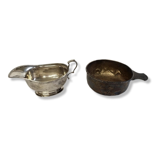 45 - AN EARLY 20TH CENTURY SILVER PORRINGER AND SAUCEBOAT
Circular form, with single handle and engraved ... 