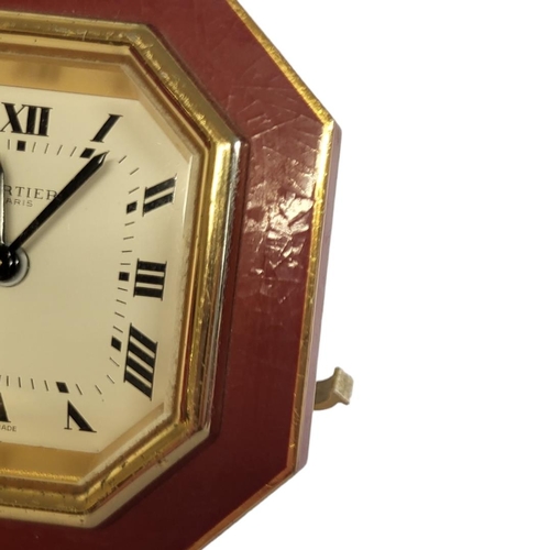 46 - CARTIER, MUST DE CARTIER, A VINTAGE GILT METAL AND ENAMEL TRAVEL CLOCK
Octagonal form with red ename... 