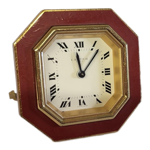 46 - CARTIER, MUST DE CARTIER, A VINTAGE GILT METAL AND ENAMEL TRAVEL CLOCK
Octagonal form with red ename... 