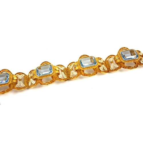 206 - A VINTAGE CONTINENTAL  SILVER GILT FILIGREE AND  PASTE  BRACELET
Having four baguette cut pale blue ... 