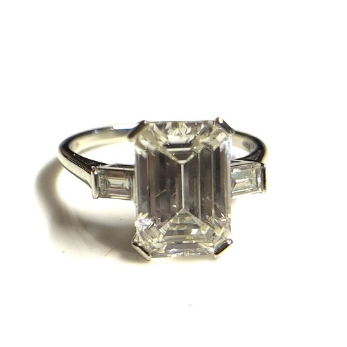 267 - AN 18CT WHITE GOLD AND 4.37CT DIAMOND SOLITAIRE RING
The faceted emerald cut stone flanked by baguet... 