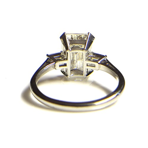 267 - AN 18CT WHITE GOLD AND 4.37CT DIAMOND SOLITAIRE RING
The faceted emerald cut stone flanked by baguet... 