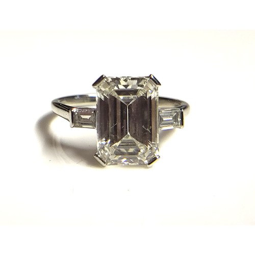 267 - AN 18CT WHITE GOLD AND 4.37CT DIAMOND SOLITAIRE RING
The faceted emerald cut stone flanked by baguet... 