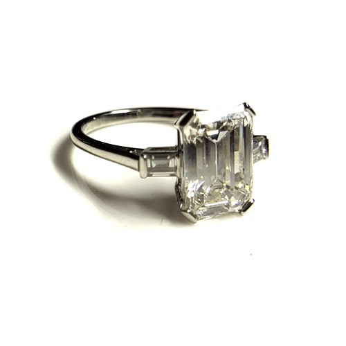 267 - AN 18CT WHITE GOLD AND 4.37CT DIAMOND SOLITAIRE RING
The faceted emerald cut stone flanked by baguet... 