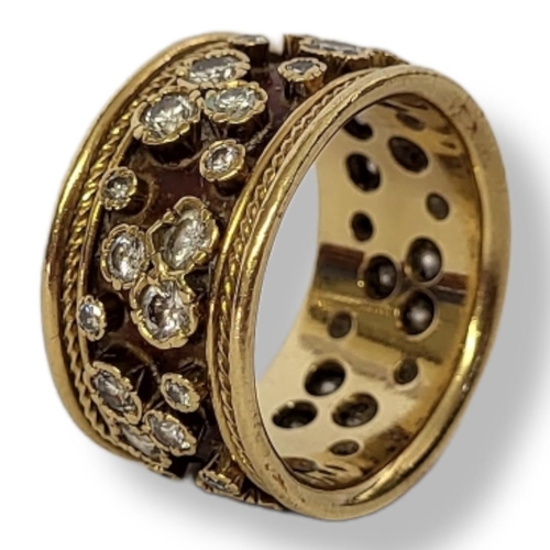 189 - AN 18CT GOLD AND DIAMOND CLUSTER RING 
The arrangement of round cut diamonds in a wide setting.
(app... 