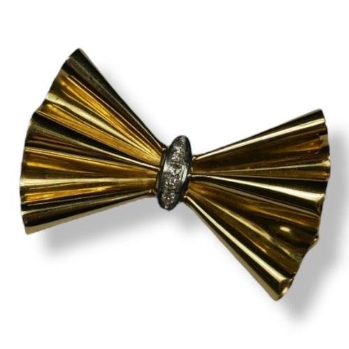 226 - A VINTAGE 18CT GOLD AND DIAMOND BOW BROOCH
The row of round cut diamonds in a geometric form.
(appro... 