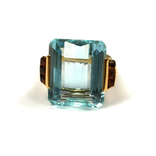 228 - A VINTAGE YELLOW METAL, AQUAMARINE AND CITRINE RING
The large step cut aquamarine flanked by two row... 