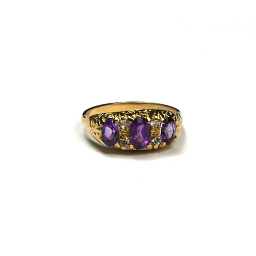 236 - A 9CT GOLD, AMETHYST AND DIAMOND THREE STONE RING
The row of three graduated oval cut amethysts inte... 