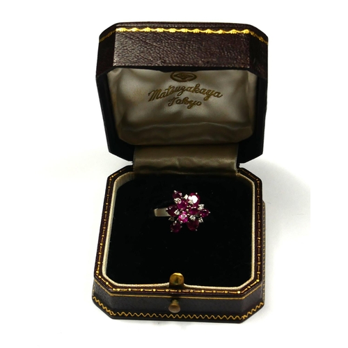 246 - A PLATINUM, RUBY AND DIAMOND CLUSTER RING
The arrangement of graduated round cut rubies interspersed... 