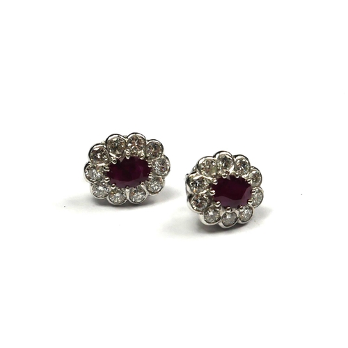 247 - A PAIR OF PLATINUM, RUBY AND DIAMOND CLUSTER EARRINGS
The oval cut ruby edged with round cut diamond... 