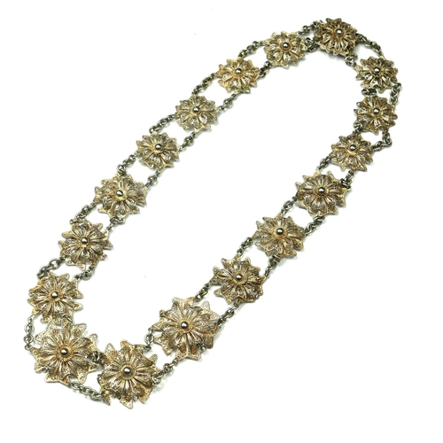 58 - AN EARLY 20TH CENTURY SILVER FILIGREE NECKLACE
Having floral form panels with fine chain link spacer... 