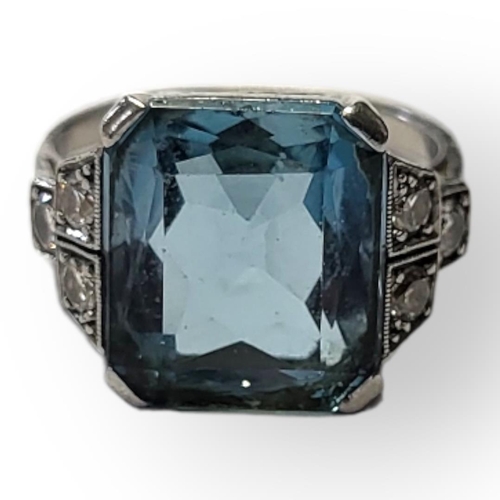 101 - A PLATINUM, AQUAMARINE AND DIAMOND RING
The single rectangular faceted cut stone flanked by round cu... 