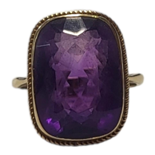 137 - AN EARLY 20TH CENTURY 9CT GOLD AND AMETHYST RING
The single rectangular faceted cut stone in a colle... 