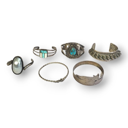 180 - A COLLECTION OF VINTAGE SILVER AND WHITE METAL BANGLES
To include a bangle set with a shell and one ... 