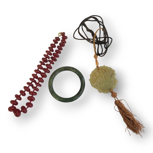 185 - A VINTAGE CHINESE JADE PENDANT
Pierced form with fabric tassel, together with a Chinese jade bangle ... 