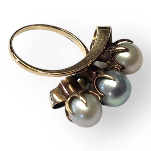 68 - A VINTAGE 14CT GOLD AND PEARL RING
Having a row of three pearls in a half twist design.
(size M/N)

... 