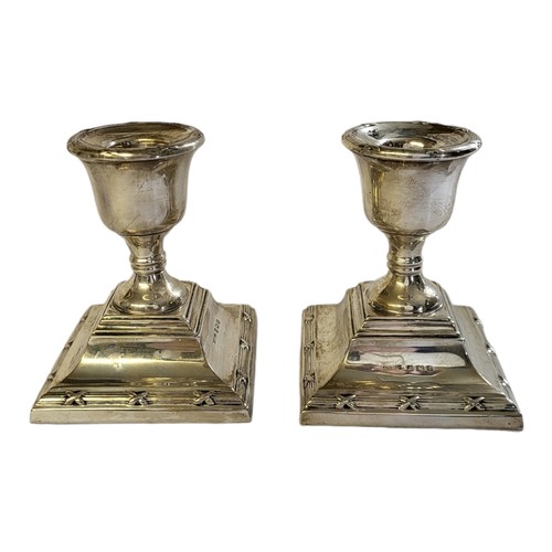 196 - A PAIR OF SMALL HALLMARKED SILVER TOP DESK CANDLESTICKS 
Birmingham, 1929, of Neoclassical shape, ra... 