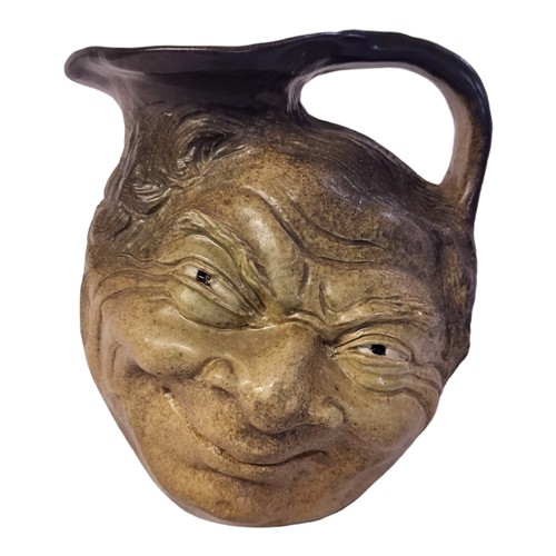 247 - AN EARLY 20TH CENTURY MARTIN BROTHERS STYLE STONEWARE EWER
Moulded with grotesque smiling figure, se... 