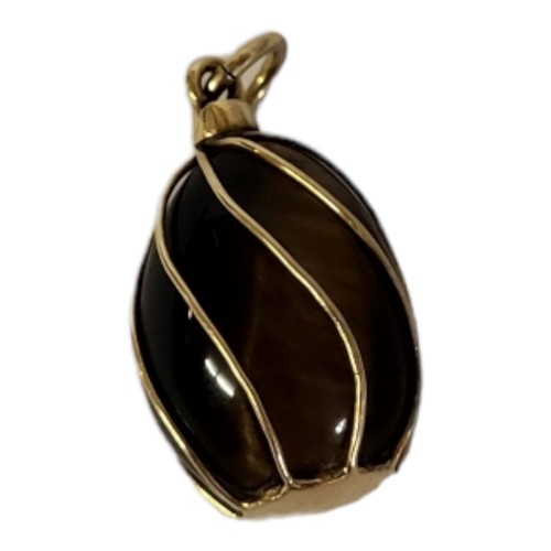 23A - A CONTINENTAL YELLOW METAL AND TIGER'S EYE PENDANT
Pear cut stone with yellow metal cage.
(approx 2c... 