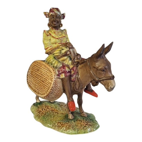 121 - A RARE BESWICK POTTERY FIGURAL GROUP, A YOUNG JAMAICAN GIRL SITTING ON A DONKEY
Titled ‘Susie Jamaic... 