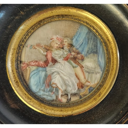 463 - A 19TH CENTURY CIRCULAR MINIATURE PAINTING ON IVORY, BEDROOM SCENE WITH COURTING COUPLE
In an ebonis... 