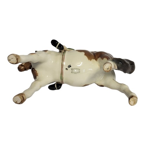 32 - BESWICK, A VINTAGE PORCELAIN 'SKEWBALL' PONY AND RIDER
Young girl wearing a black hat and green ridi... 